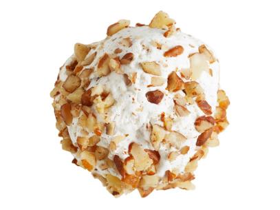 A white sphere shaped cookie covered in chopped nuts