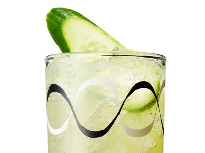 A Cocktail With a Slice of Cucumber in a Glass with Decorative White and Black Waves on it