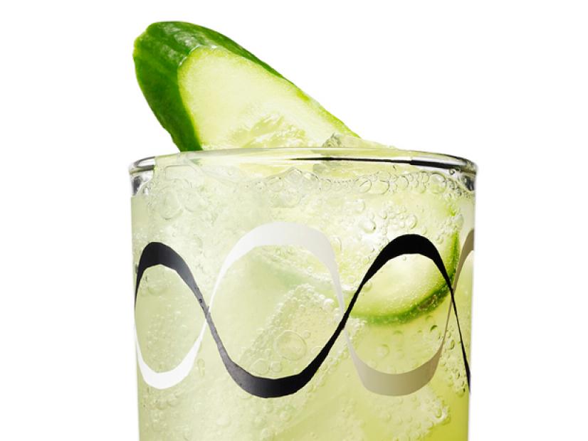 A Cocktail With a Slice of Cucumber in a Glass with Decorative White and Black Waves on it