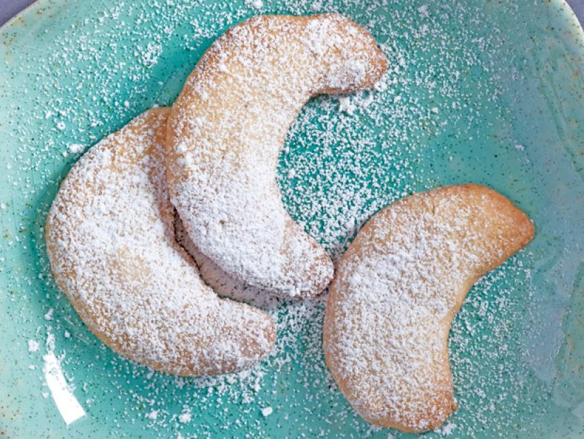Mexican Wedding Cookies with powder sugar on a grainy blue dish