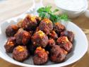 A dish full of cinnamon meatballs with cheese