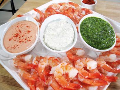 A Variety of Shrimp Cocktail Aligned in a row on a tray full of shrimp