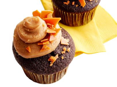 Mini Chocolate Cupcakes with candy bar toppings on a yellow napkin