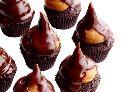 Mini Chocolate Cupcakes in brown cupcake wrappers topped with Reeses toppings