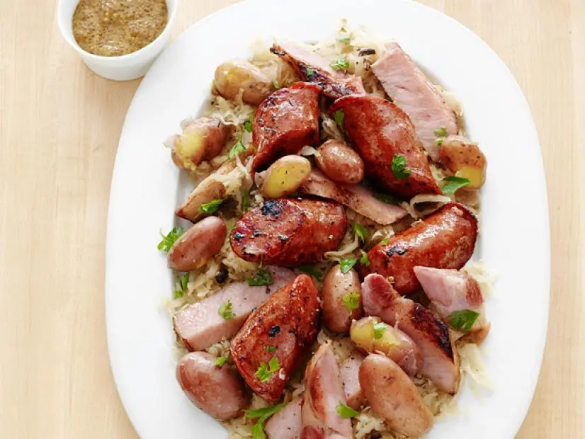 Sauerkraut mixed with pork and potatoes on an oval white plate