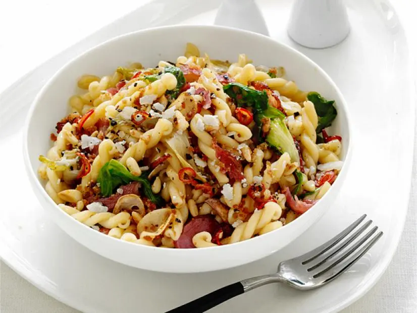 Pasta and vegetables mixed in a white bowl