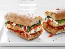 Tofu and Parmesan Sandwich sliced in half on a white tray