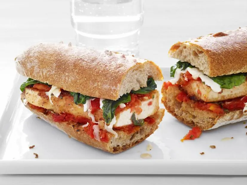 Tofu and Parmesan Sandwich sliced in half on a white tray