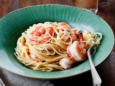 Pasta with shrimp mixed in a green bowl