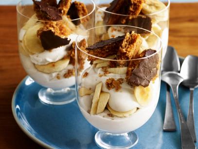 Three dessert dishes made of layers of cream, candy bar pieces and bananas