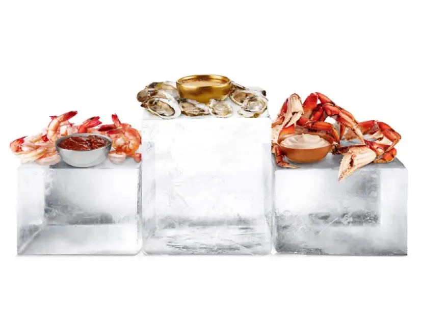 Three sauces surrounded by dipping foods and placed on three individual blocks of ice