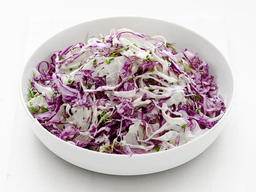 Slaw garnished with herbs in a white bowl