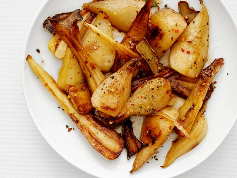 Pieces of pear coated with ginger on a white plate