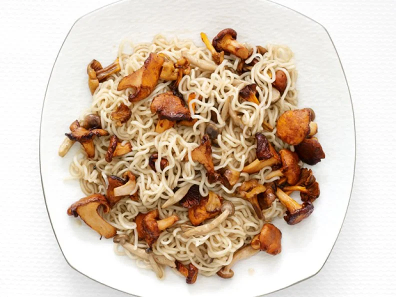 Mixture of mushrooms and ramen noodles on a white plate