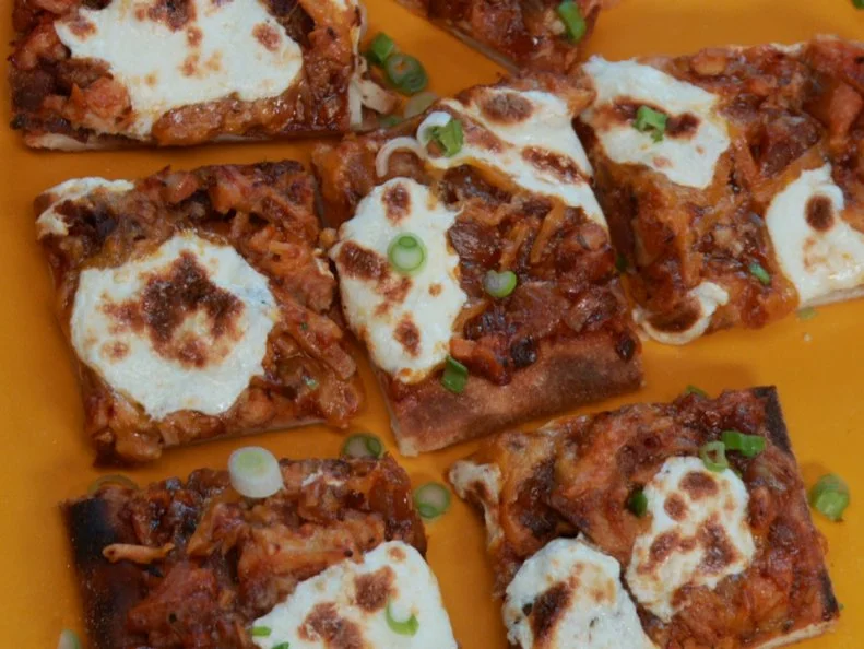 Square pizza slices on an orange platter
