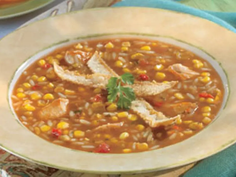 Chicken Torilla soup garnished with bread and herfs in a tan bowl