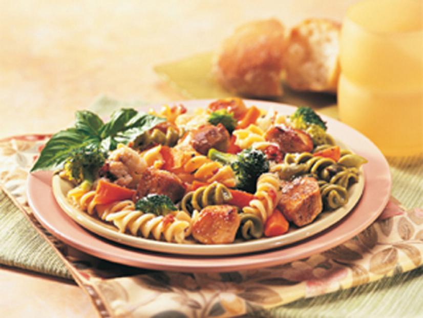 Chicken Pasta Medley garnished with herbs on a pink plate