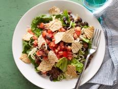 With mounds of chili-spiced beef and sharp Cheddar over crisp greens, doused with a chunky tomato lime dressing and topped with corn chips, Ellie Krieger's healthy taco salad recipe is hearty enough to satisfy even the biggest appetites.