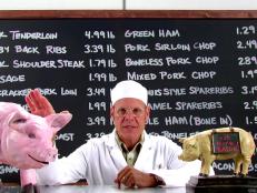 Alton Brown with pigs and chalkboard.