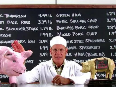 Alton Brown with pigs and chalkboard.