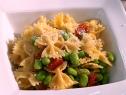 Edamame and pasta are served in a square dish.