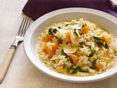 Risotto with Vegetables in a White Dish beside a Purple Napkin