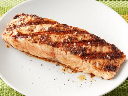 Seasoned and Grilled Salmon in a White Dish on A Green Place Setting