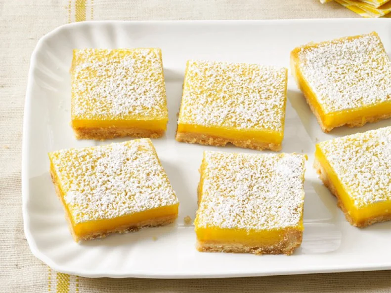 Squares of dessert topped with powdered sugar
