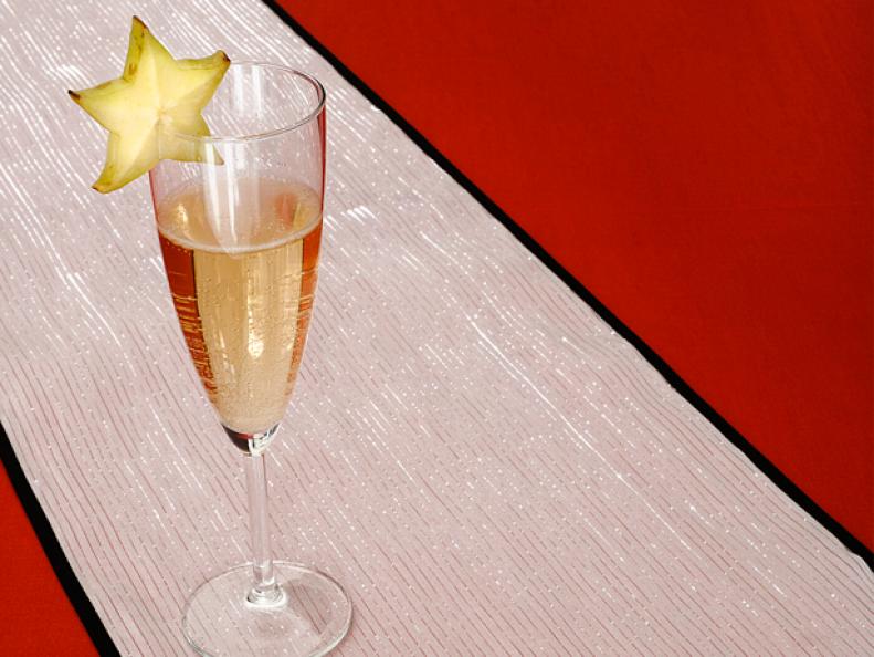 A glass of champagne garnished with a star fruit