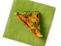 A fourth of a sandwich on a green napkin