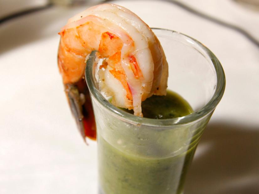 A single shrimp on shot glass full of dip