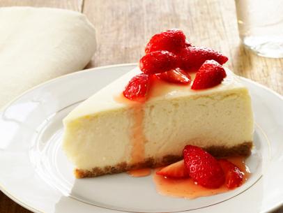 A slice of cheesecake topped with strawberries