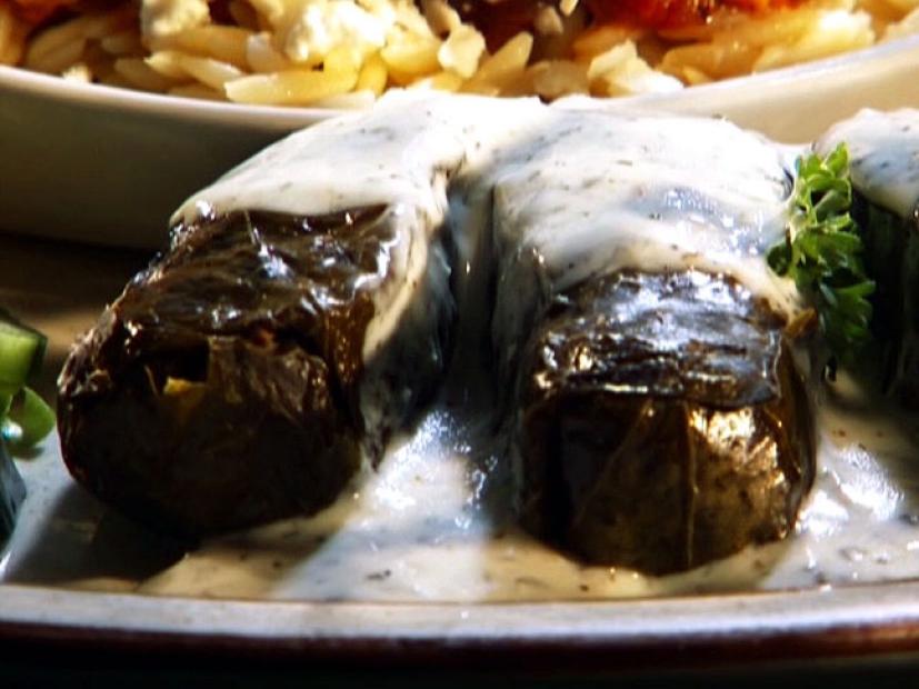 Salmon wrapped in grape leaves and covered in white sauce