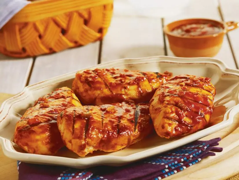 Grilled barbecue chicken breasts on a cream colored dish