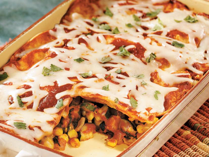 Layered Enchilada Casserole in a white baking dish with brown trim