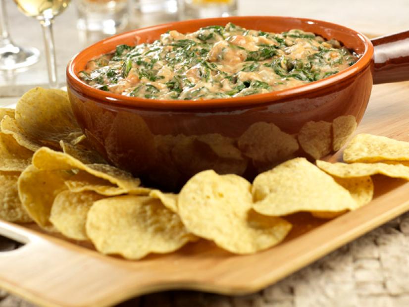 Spinach Dip in a brown bowl surrounded by round tortilla chips