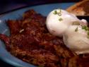Corned beef hash on a plate served with two eggs.