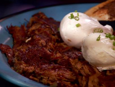 Corned beef hash on a plate served with two eggs.