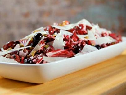 Radicchio and grape salad with pecorino and pistachios served in a white platter.