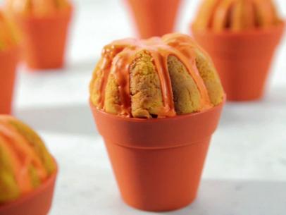 Pumpkin cupcakes baked in mini pumpkin cake molds and drizzled with an orange pumpkin icing.