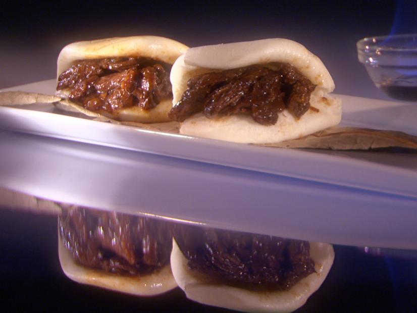 Two Skirt Steaks on a narrow white plate with two containers of sauce