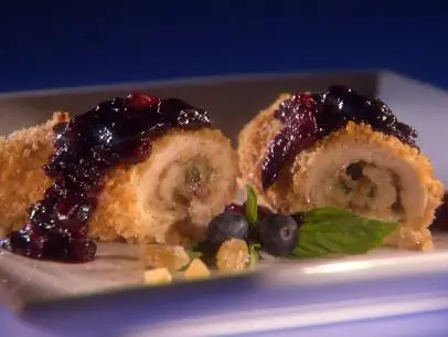 Two Chicken Rolls covered with sauce on a square white plate