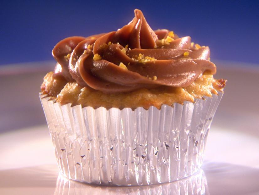 A Plantain Cupcake in a silver cupcake wrapper placed on a small white plate