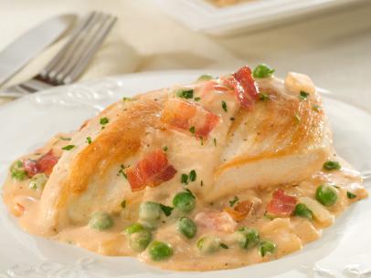 Chicken Breast topped with and in a pool of creamy vegetable sauce