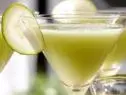 Zucchini tini is served in a martini glass garnished with a thin slice of zucchini.