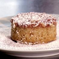 Strawberry upside down cake is sprinkled with powdered sugar.