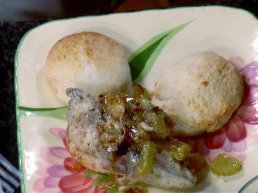 Smothered chicken and biscuits is topped with sauteed celery, onions, and scallions.