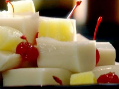 Coconut jelly is served with pineapple chunks and maraschino cherries.
