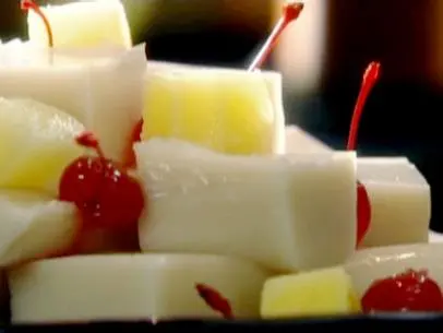 Coconut jelly is served with pineapple chunks and maraschino cherries.