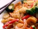 Shrimp with garlic sauce is served with broccoli florets, water chestnuts, onions, and chopped red bell pepper.